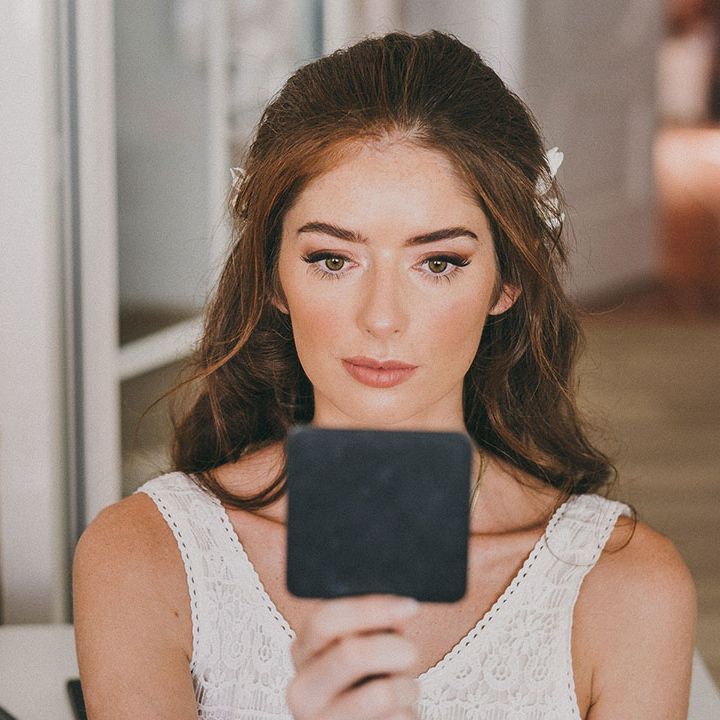 Bride with long dark hair with natural bridal makeup up and glowy skin