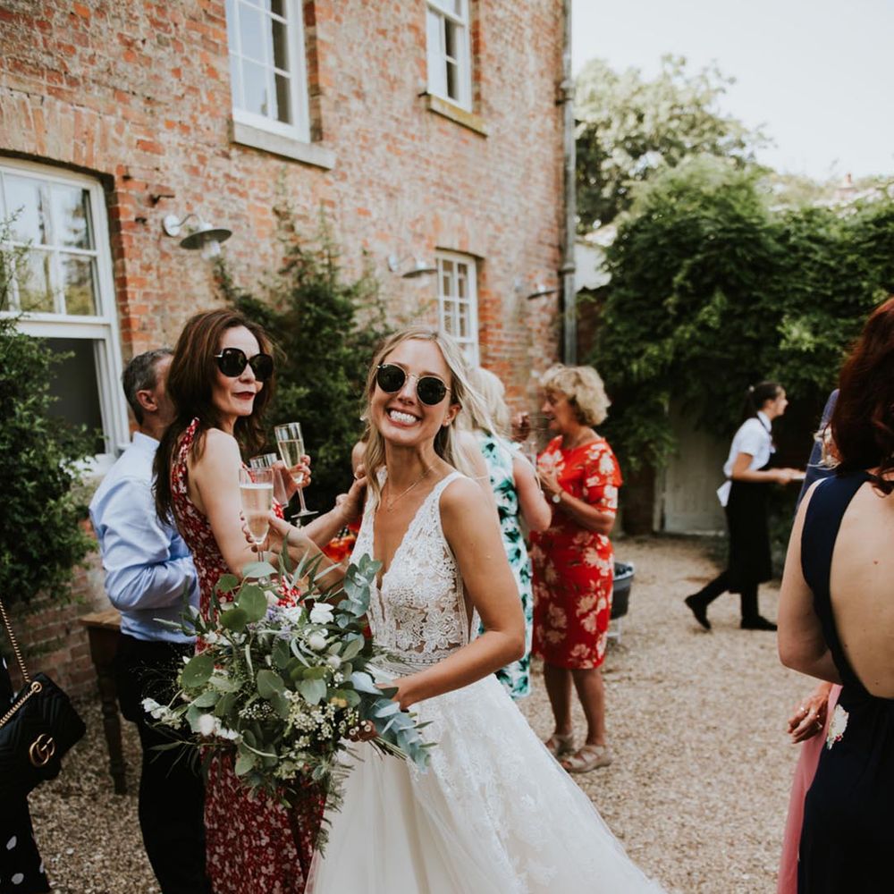 bride wearing black wedding sunglasses for summer wedding