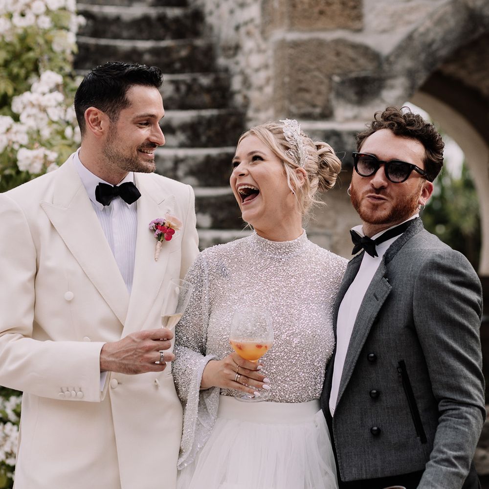 bride-and-groom-laughing-with-wedding-guest-with-cocktail