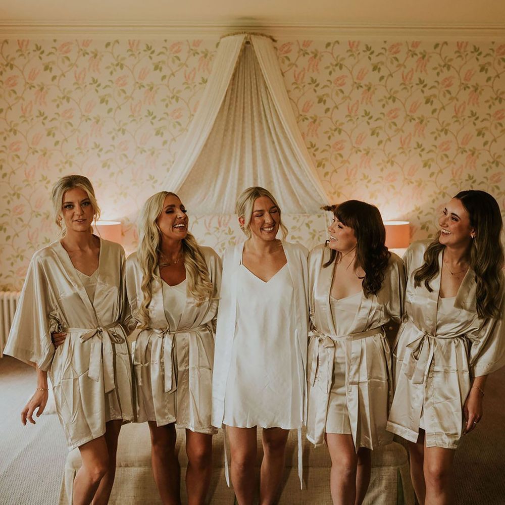 Bridal party wearing gold satin robes and pyjamas with bride in white