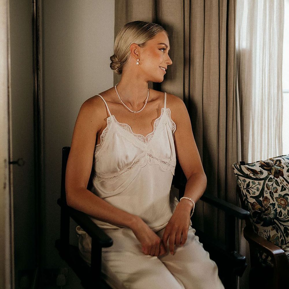 Bride getting ready for the wedding wearing white satin cami pyjamas
