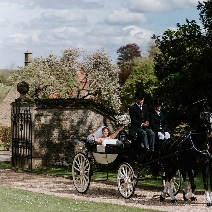 bride riding in horse and carriage to wedding