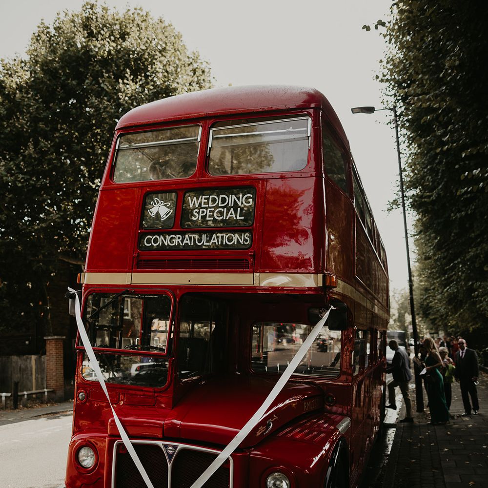red double decker bus with white ribbon