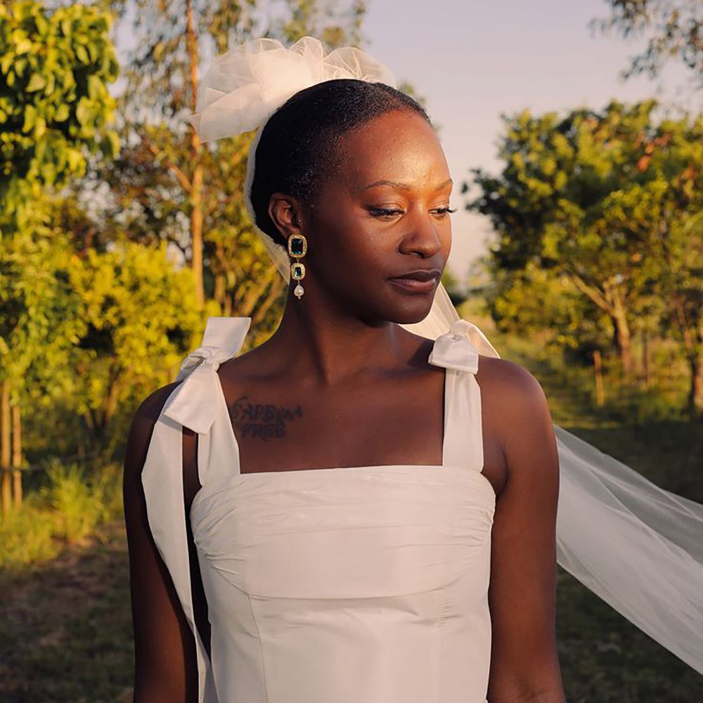 Bride wearing emerald and gold wedding earrings