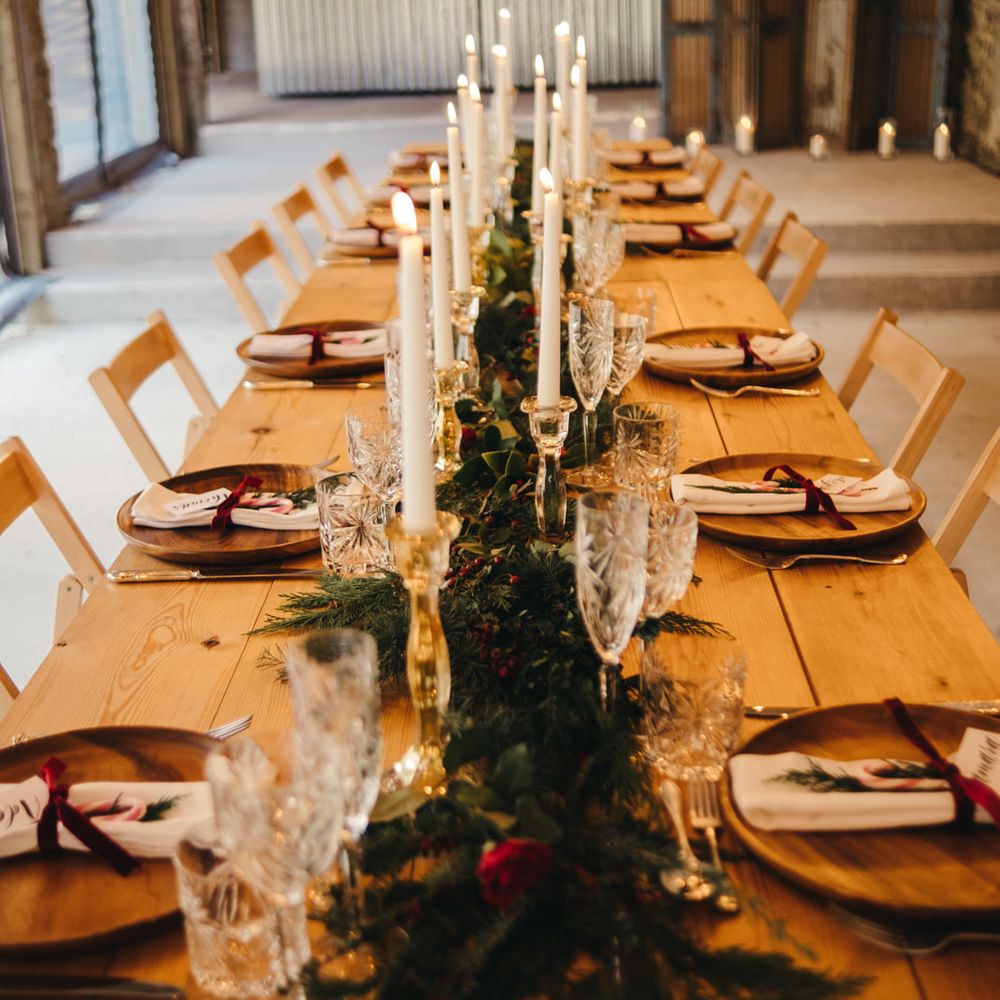 Long wooden banquet table with evergreen fir table runner