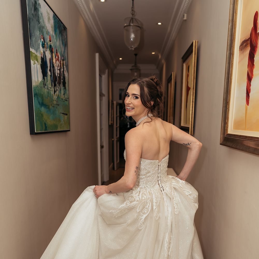 Bride running down the hallway in strapless wedding gown