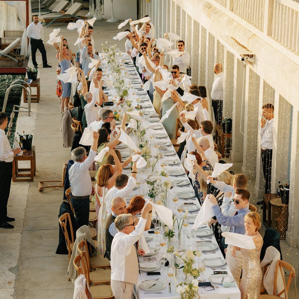 outdoor-wedding-breakfast-with-guests-waving-napkins