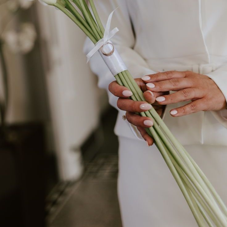 Bride with Light Pink Almond Wedding Nails Carrying Lily Bouquet