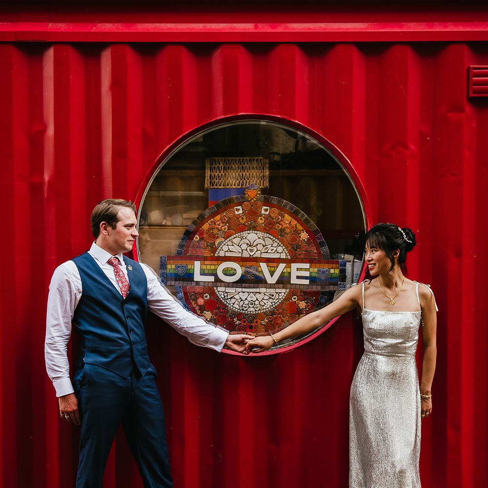 Bride in The Vampire's Wife wedding dress with groom at industrial venue