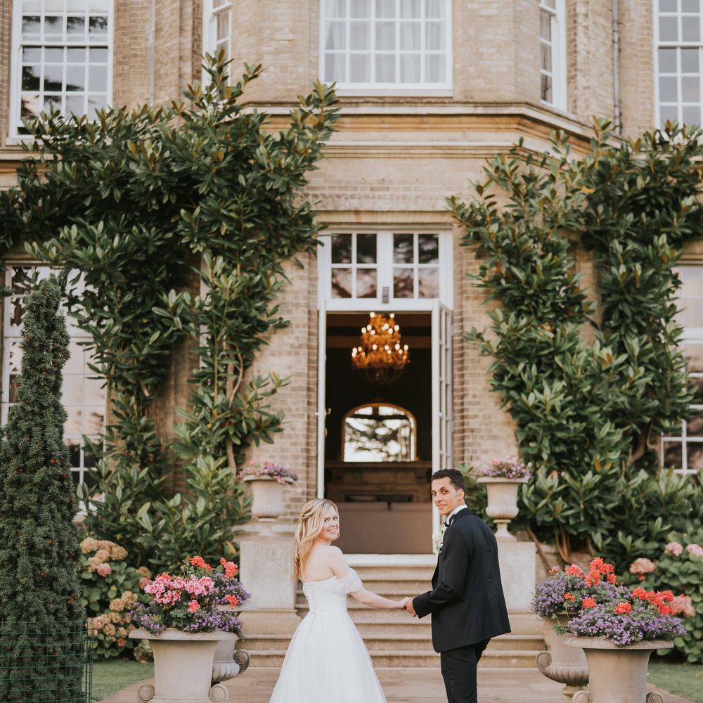 Bride and groom walk upstairs together at country house wedding venue