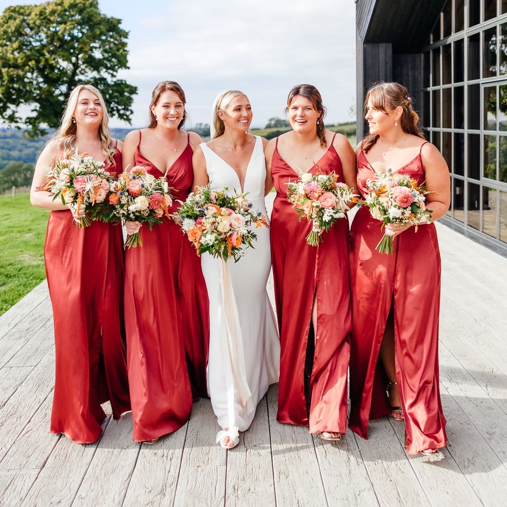 Bridal party wearing red satin bridesmaid dresses