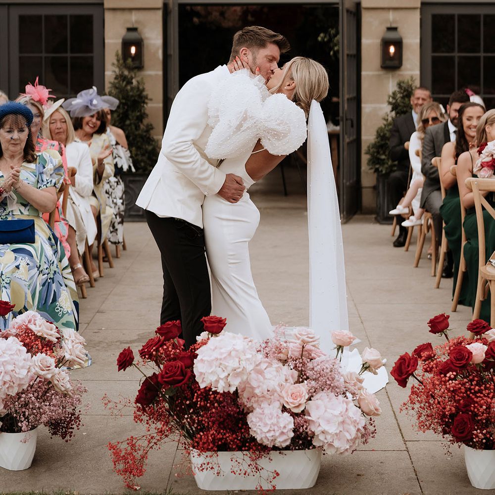 First kiss moment for the bride and groom at outdoor wedding