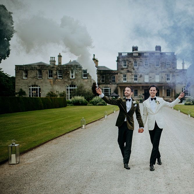 Couple waves smoke flares at Yorkshire country house wedding