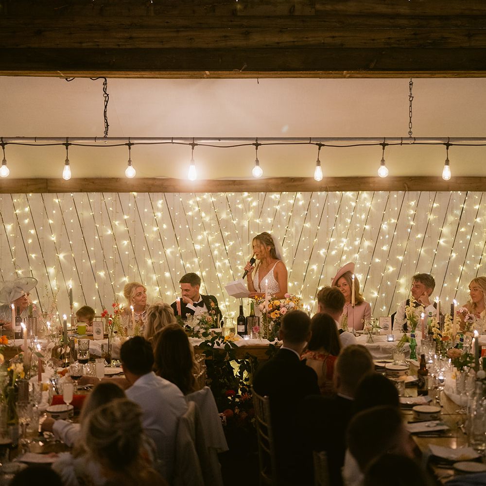 Bride stands reading out wedding speech 