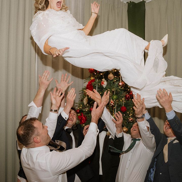 groomsmen-throw-bride-into-the-air.