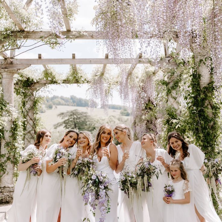 Beautiful Bridesmaids in White Dresses with Lilac Bouquets