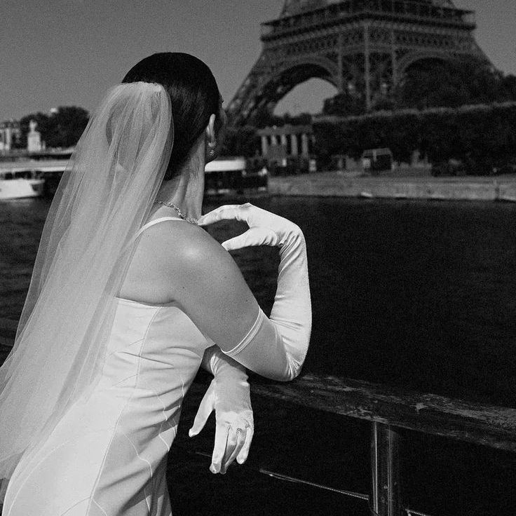 Bride Wearing Satin Wedding Dress With Satin Gloves Looking At Eiffel Tower