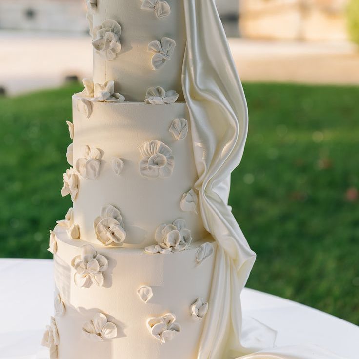 Three Tiered White Wedding Cake with Flowers & Draping Detail