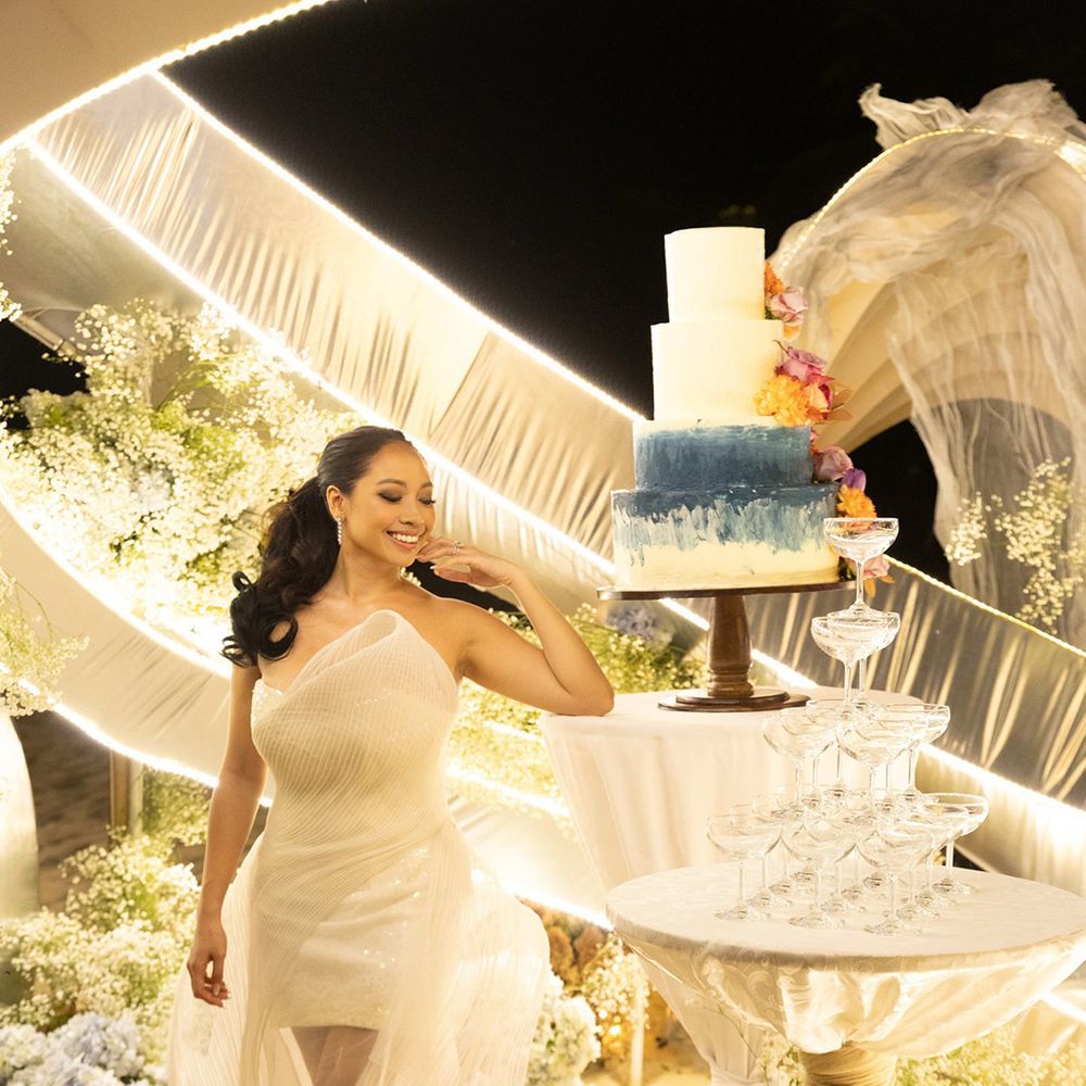 bride-in-reception-dress-looking-at-wedding-cake