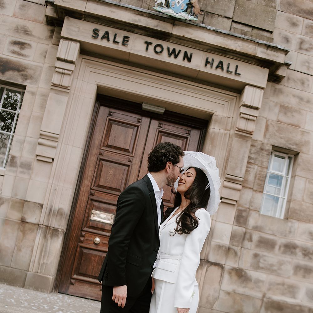 bride-in-white-bridal-suit-and-groom-in-tuxedo-at-registry-office-wedding