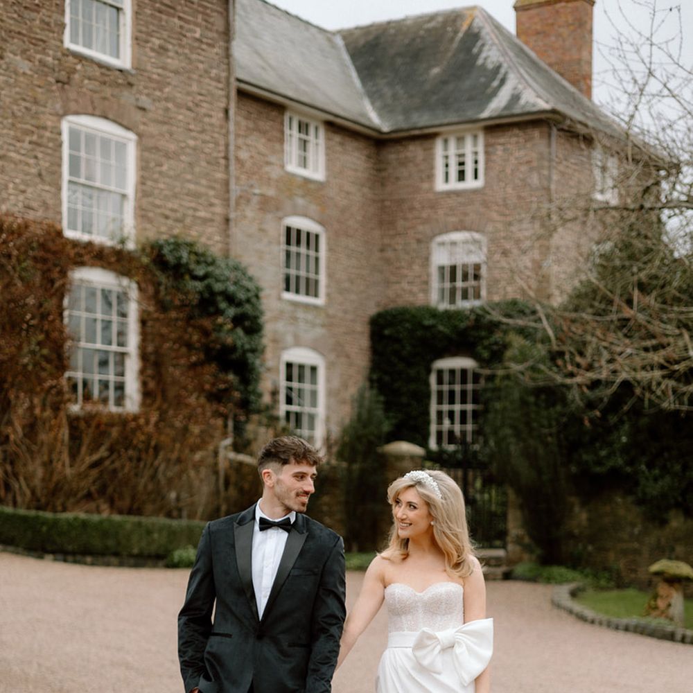 Bride and groom walking around venue at Dewsall Court 