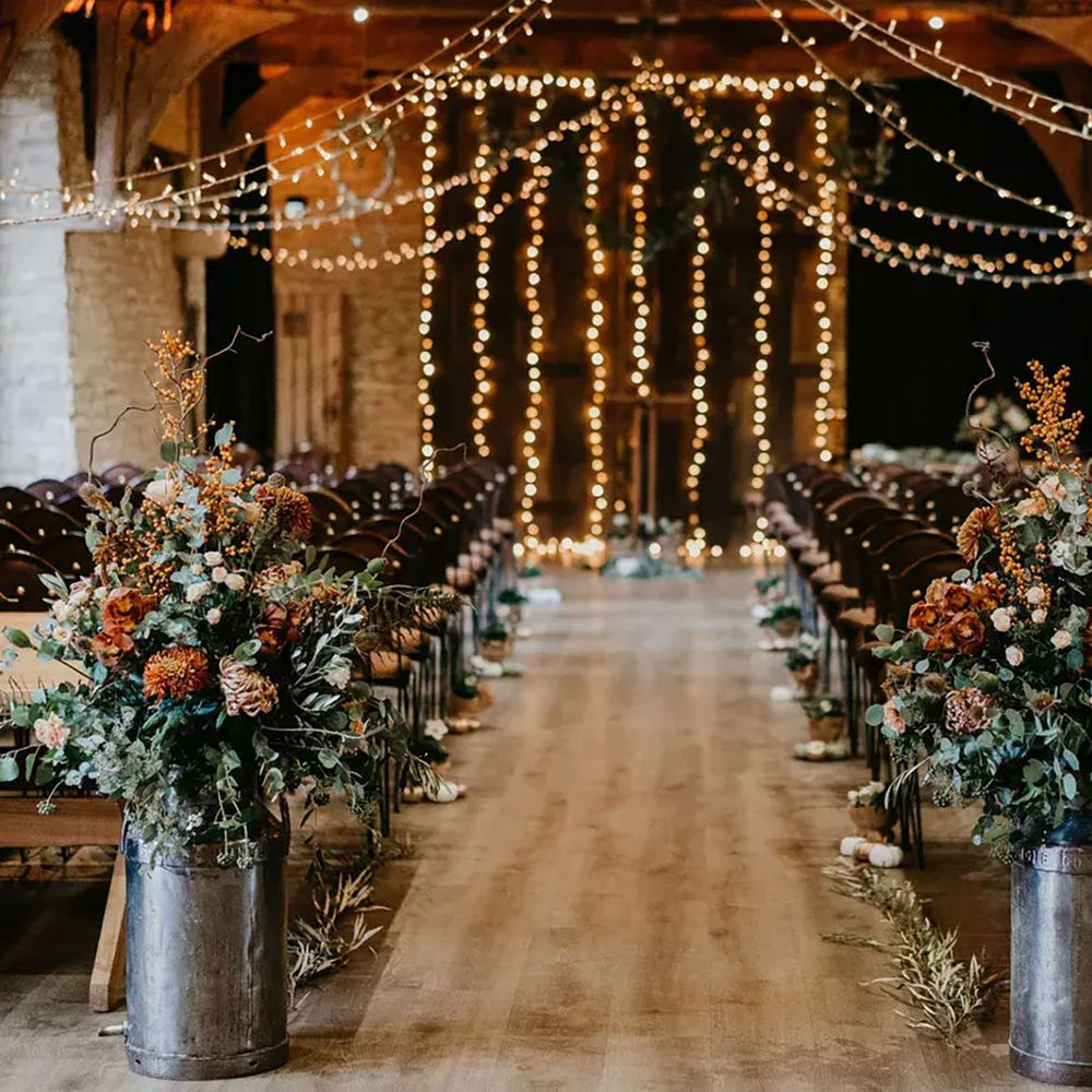 Tythe wedding ceremony space with fairy lights and flowers 