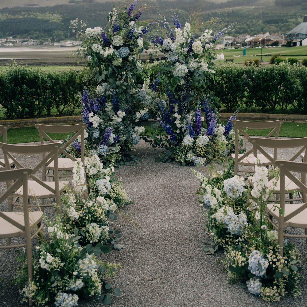 Outdoor wedding aisle with white flowers
