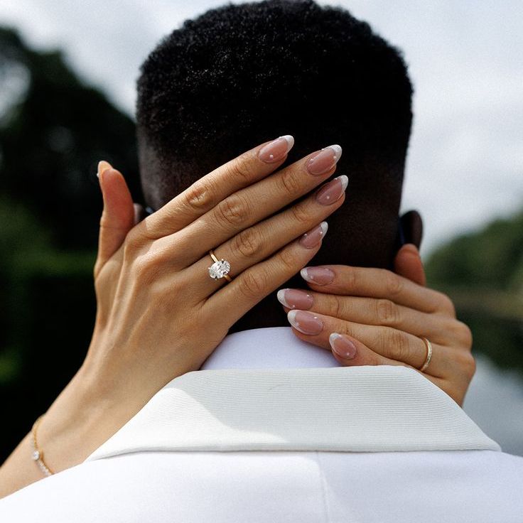 Oval Solitaire Diamond Engagement Ring Worn By Bride With French Tip Pearl Wedding Nails