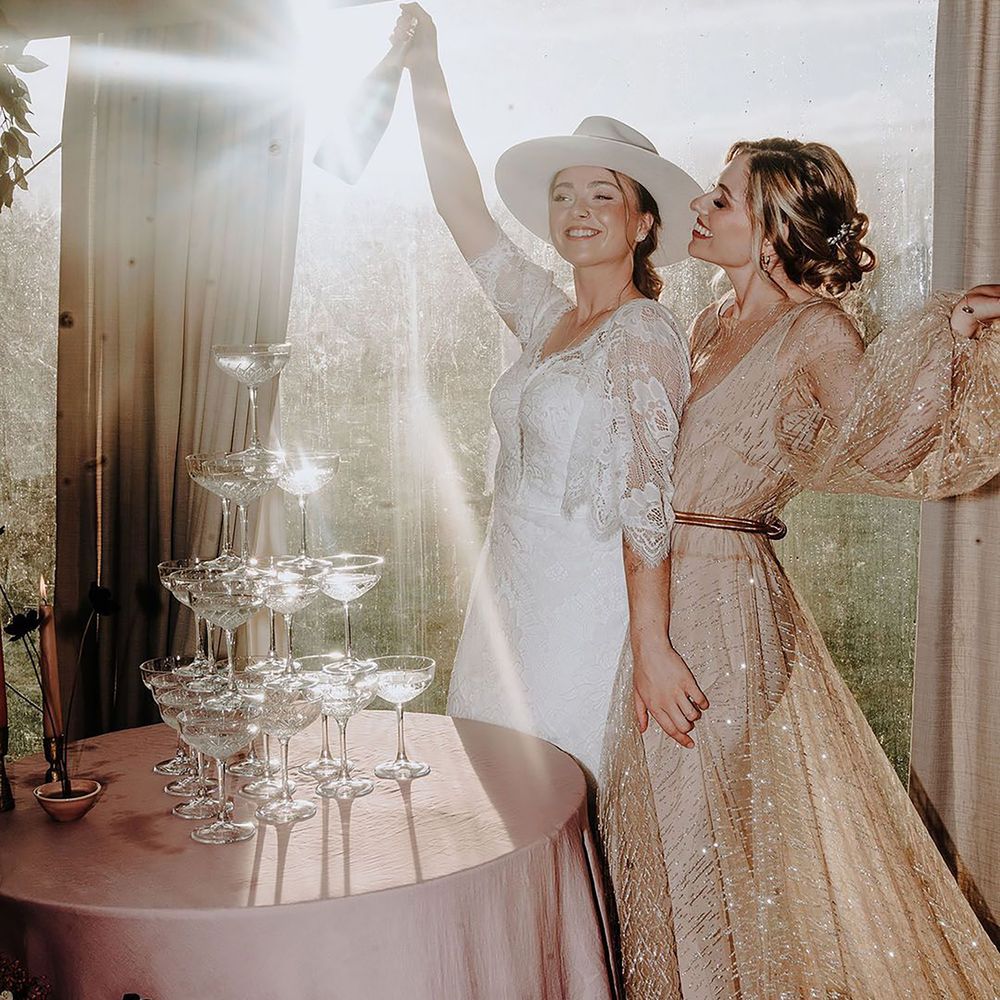 Couple in sparkly wedding outfits with champagne tower