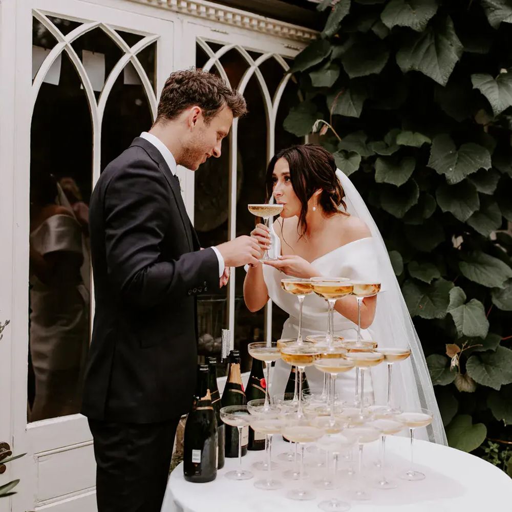Dewsall Court champagne tower bride sipping cocktail