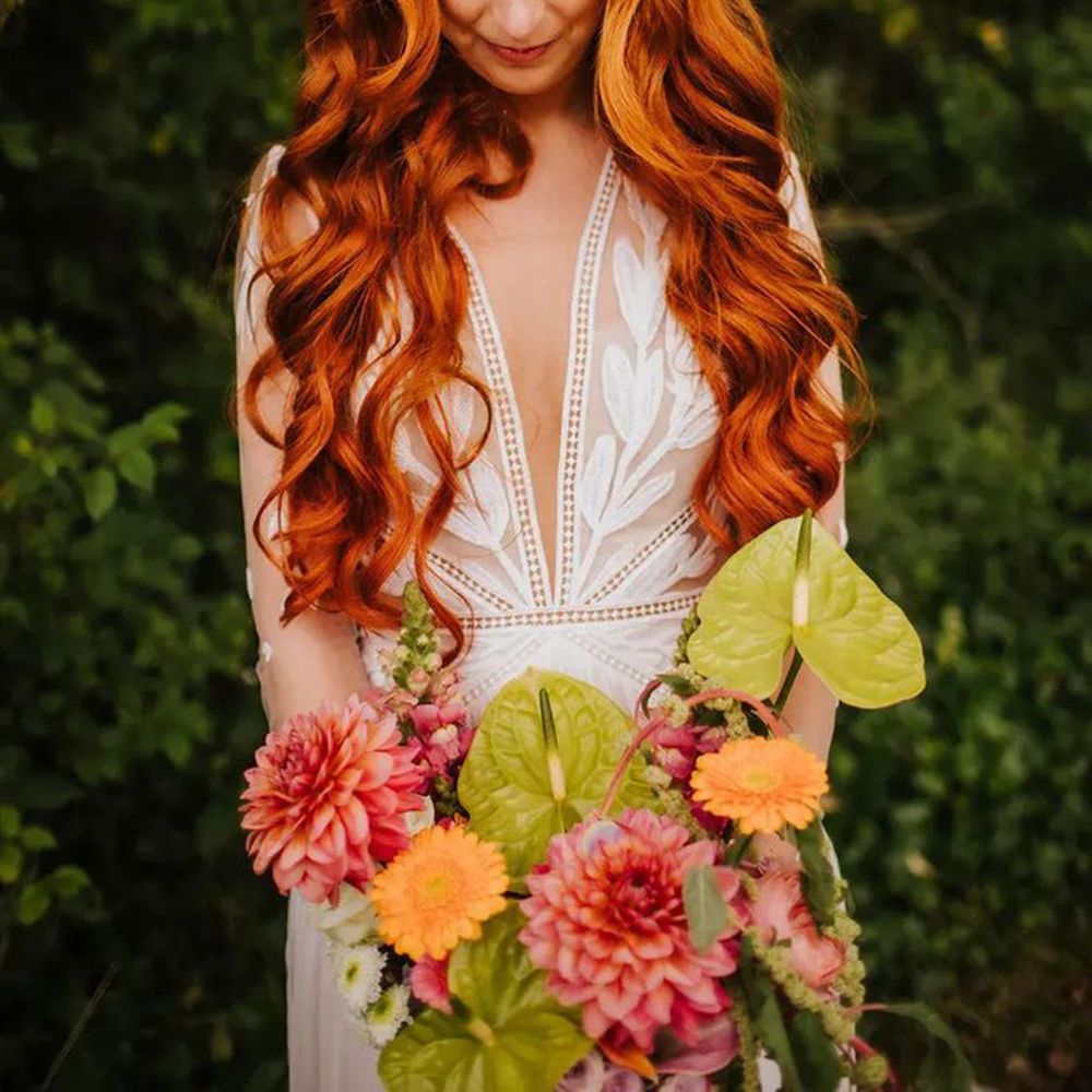 Bride in Boho Lace Wedding Dress with Long Wavy Red Hair