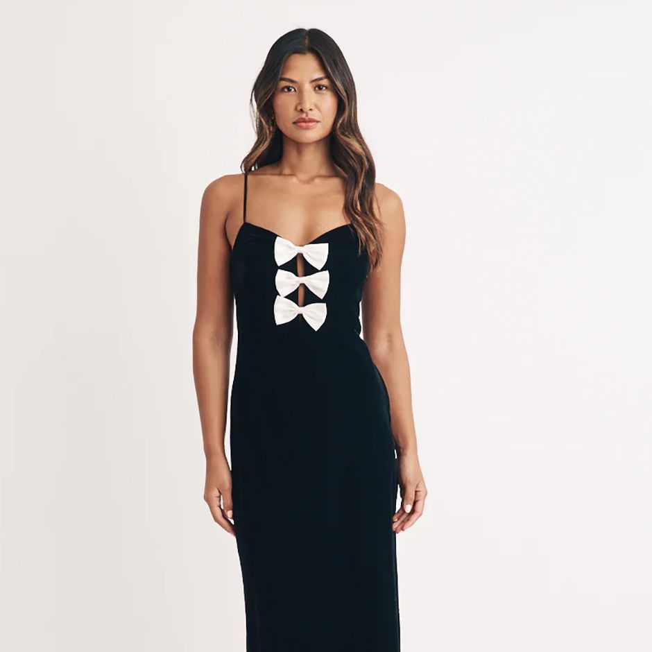 black velvet black tie wedding guest dress, featuring trio of bows in the centre of the bodice and a-line skirt