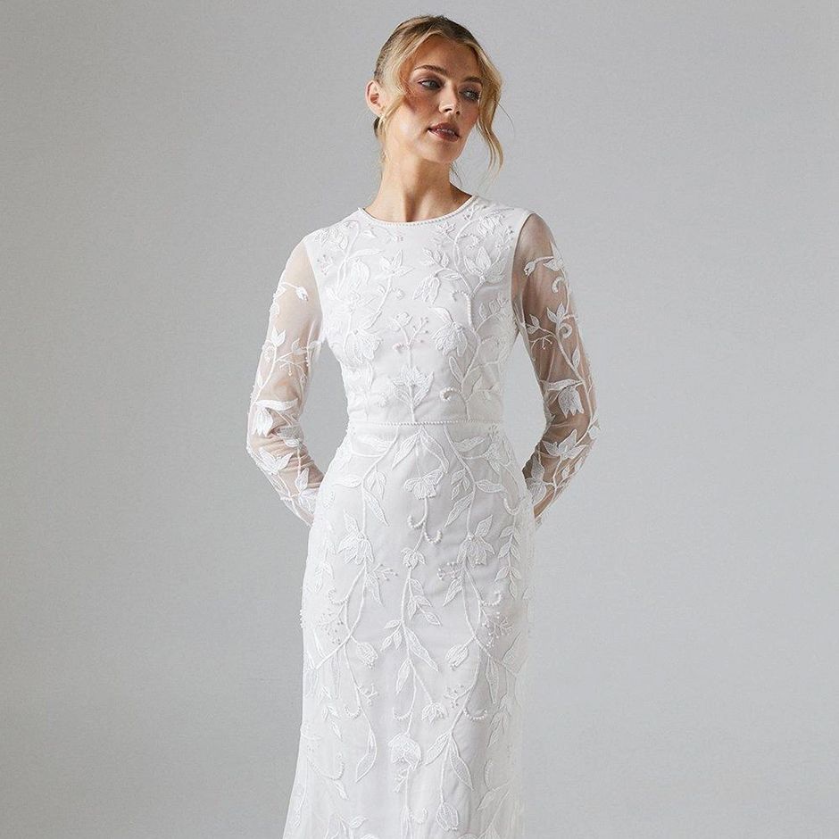 vintage style wedding dress with floral embellishments and long sleeves