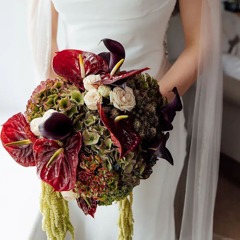 Bride holding burgundy and green wedding bouquet