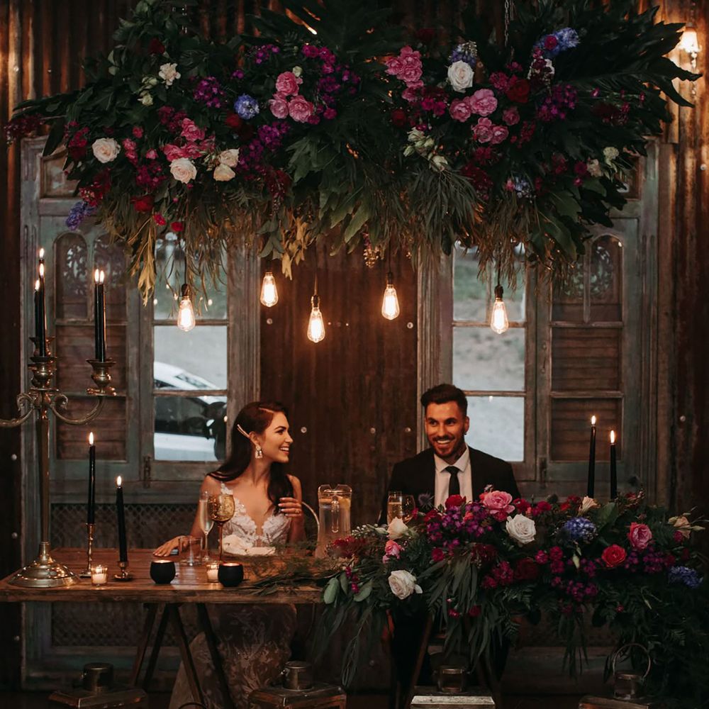 Jewel toned romantic wedding top table with candle lighting