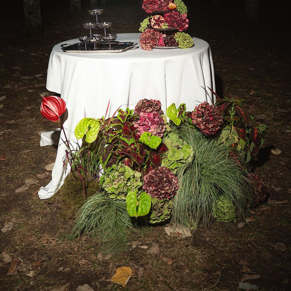 Burgundy and green colour trend wedding flowers on oval table