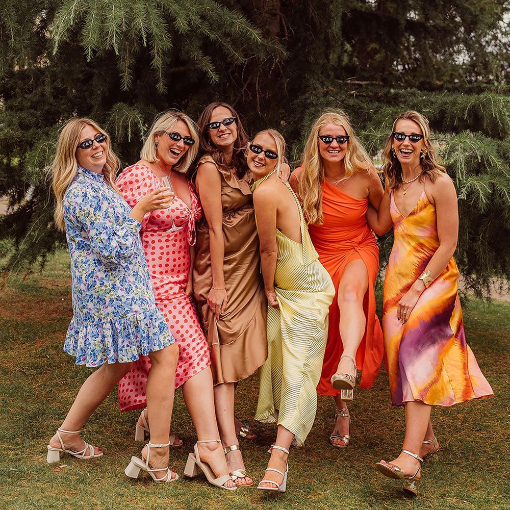 Group of spring wedding guests wearing colourful patterned dresses