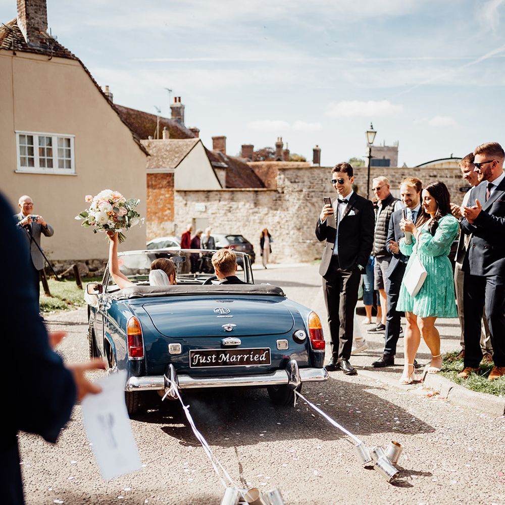 blue-wedding-car-with-tin-cans-and-just-married-signs