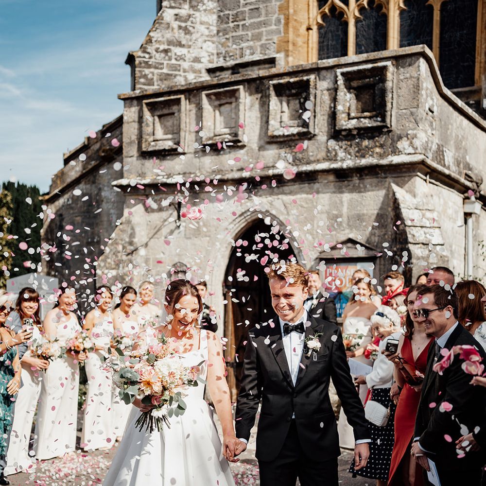 bride-and-groom-at-church-wedding-with-pink-confetti
