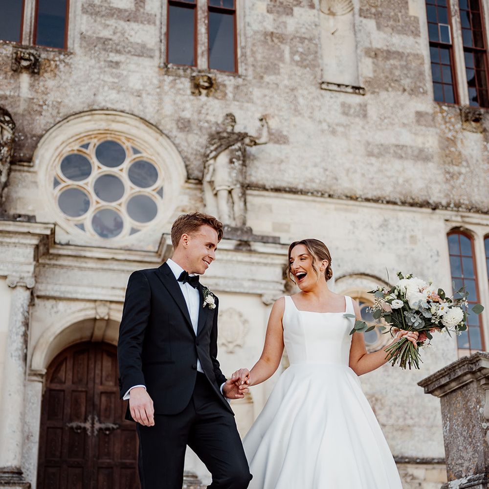 bride-in-wedding-dress-with-groom-in-black-tuxedos-at-castle-wedding