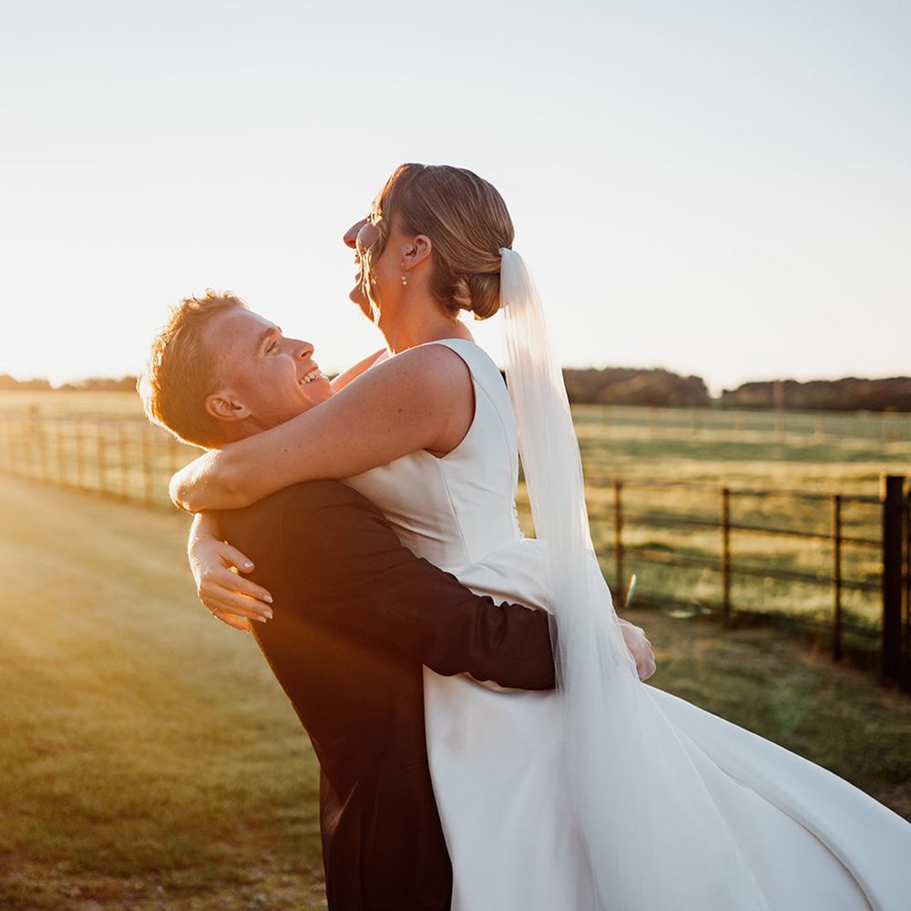 groom-lifts-the-bride-for-romantic-couple-portrait-during-golden-hour
