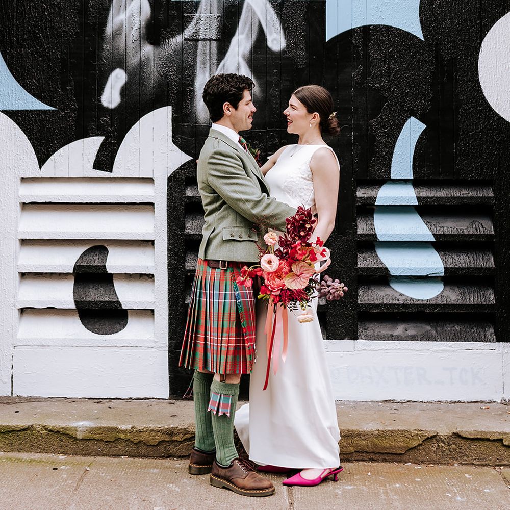bride-and-groom-pose-for-wedding-photo-in-front-of-painted-background