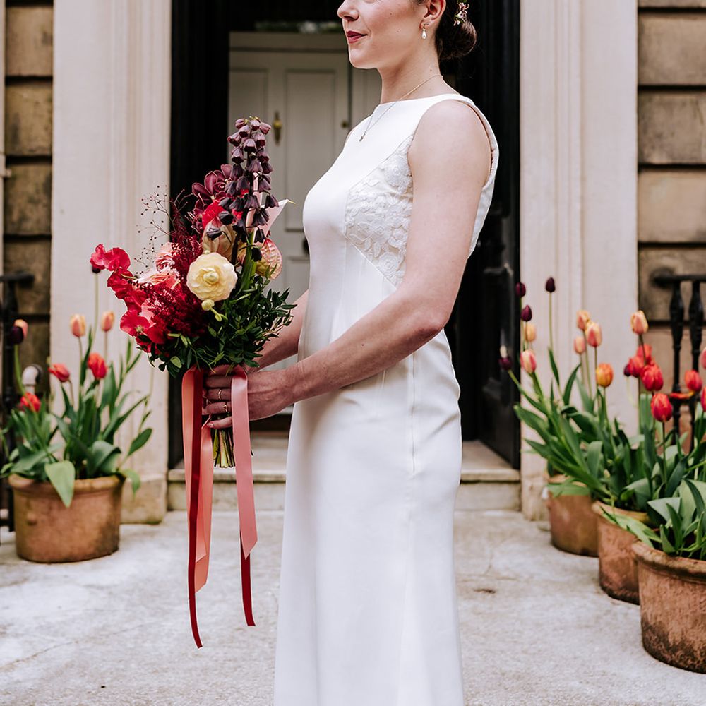 bride-in-high-neck-wedding-dress-with-red-wedding-bouquet