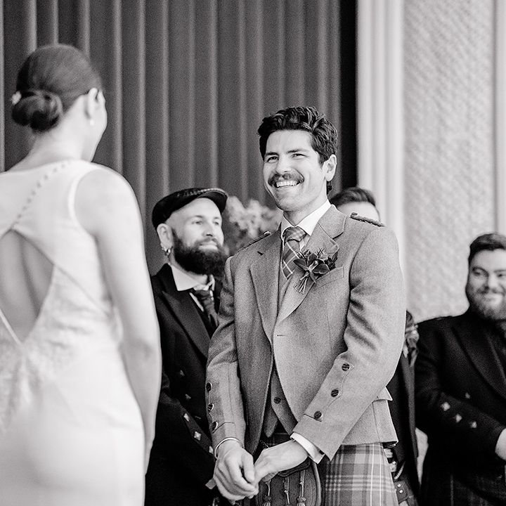 groom-smiles-at-bride-for-wedding-ceremony