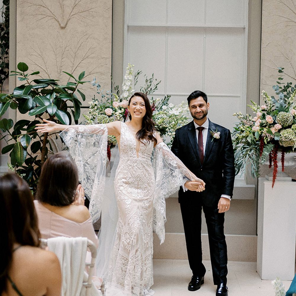 bride-wears-lace-wedding-dress-with-bat-wing-sleeves-next-to-groom