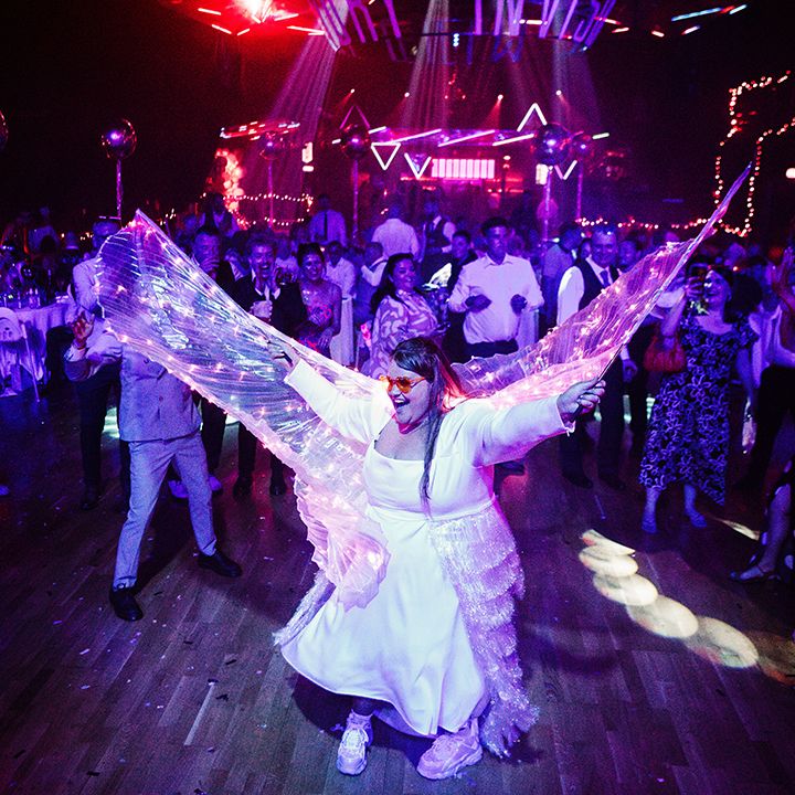 Bride dances in light up wings for wedding reception 