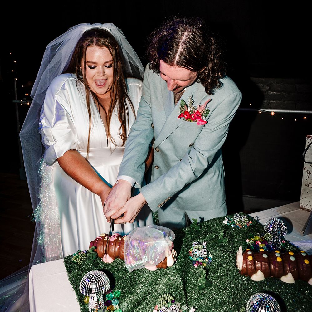 bride-and-groom-cut-colin-the-caterpillar-wedding-cake