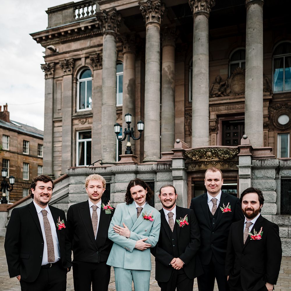 light-blue-groom-suit-with-groomsmen-in-black-suits