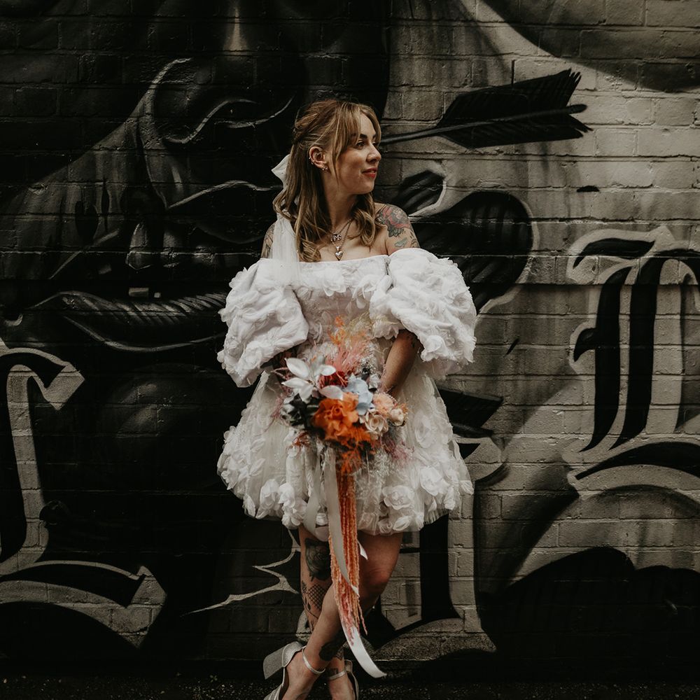 bride-in-off-the-shoulder-ruffle-wedding-dress-with-metallic-bouquet-and-platform-shoes