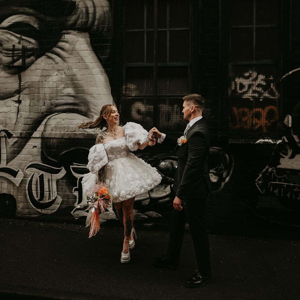 bride-in-short-wedding-dress-with-groom-in-black-suit-at-industrial-wedding